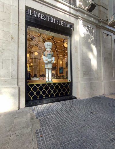 Escaparate de día de Lucciano's Málaga con la figura del heladero